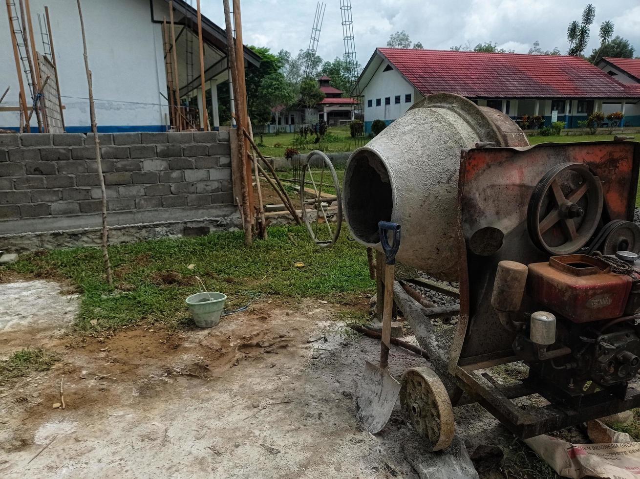 a concrete mixer installed on a construction site next to a pile of sand and gravel. photo