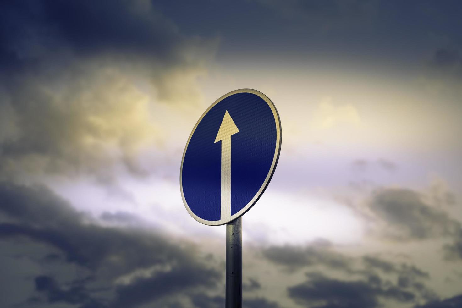 Road sign on the background of the sky with clouds photo