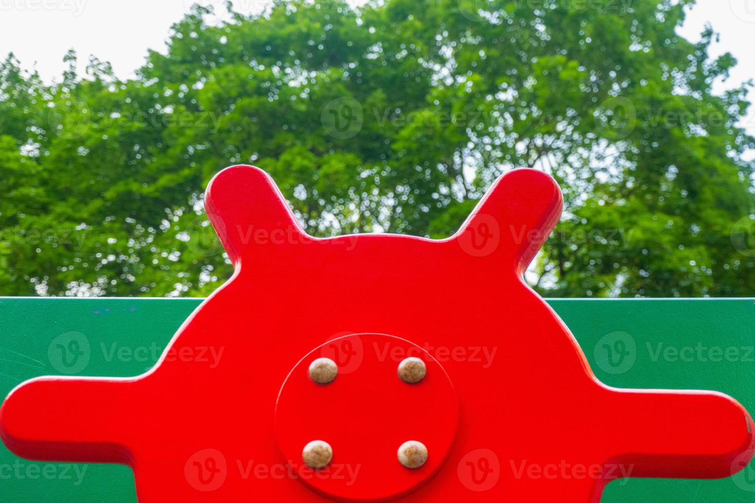 An element of a children's swing. steering wheel . An outdoor colorful playground next to the house. A summer day. Children's playground with rubber floor covering. photo