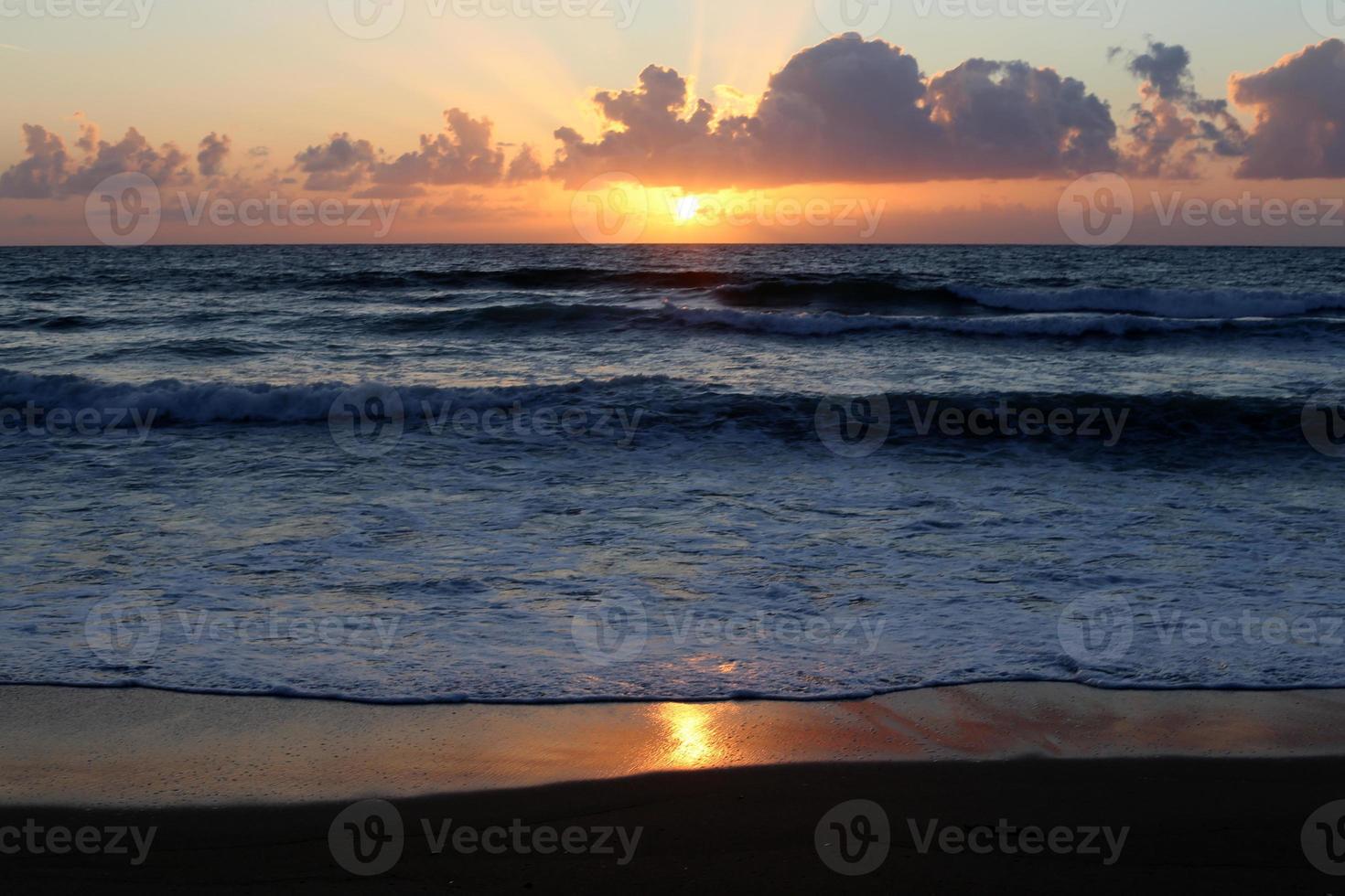 The sun sets below the horizon on the Mediterranean Sea in northern Israel. photo