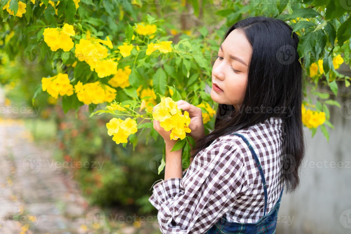 retrato joven con flores amarillas, chica asiática. foto