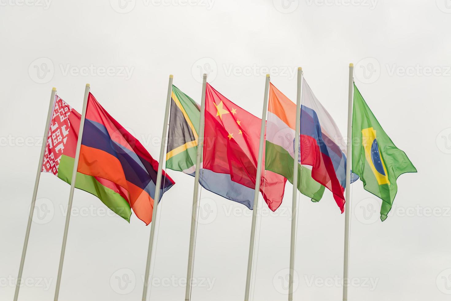 Waving flags of the BRICS countries against the blue sky. photo