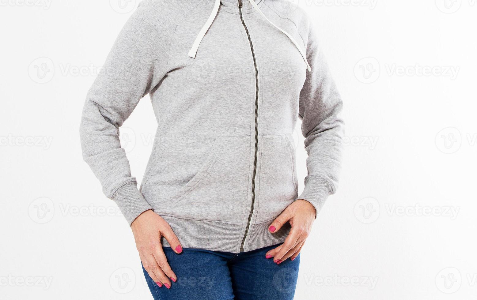 Young hipster woman girl wearing blank cotton sweatshirt with area for your logo, mock-up of grey women's hoodie, white wall in the background with copy space for your design or content photo