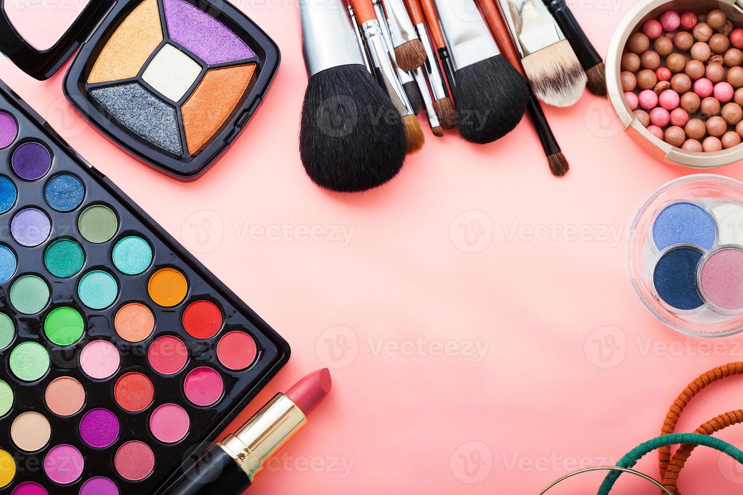 Frame of cosmetic accessories on pink background with copy space. Top view photo