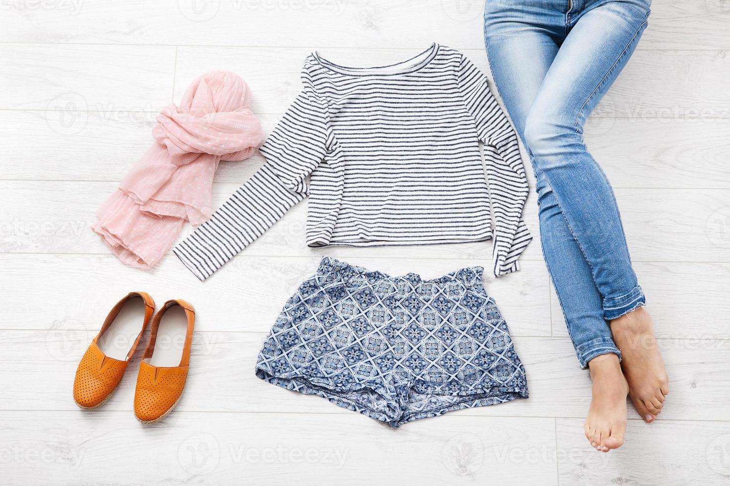 Collection collage of women's clothing and female legs on white wooden background. Top view photo