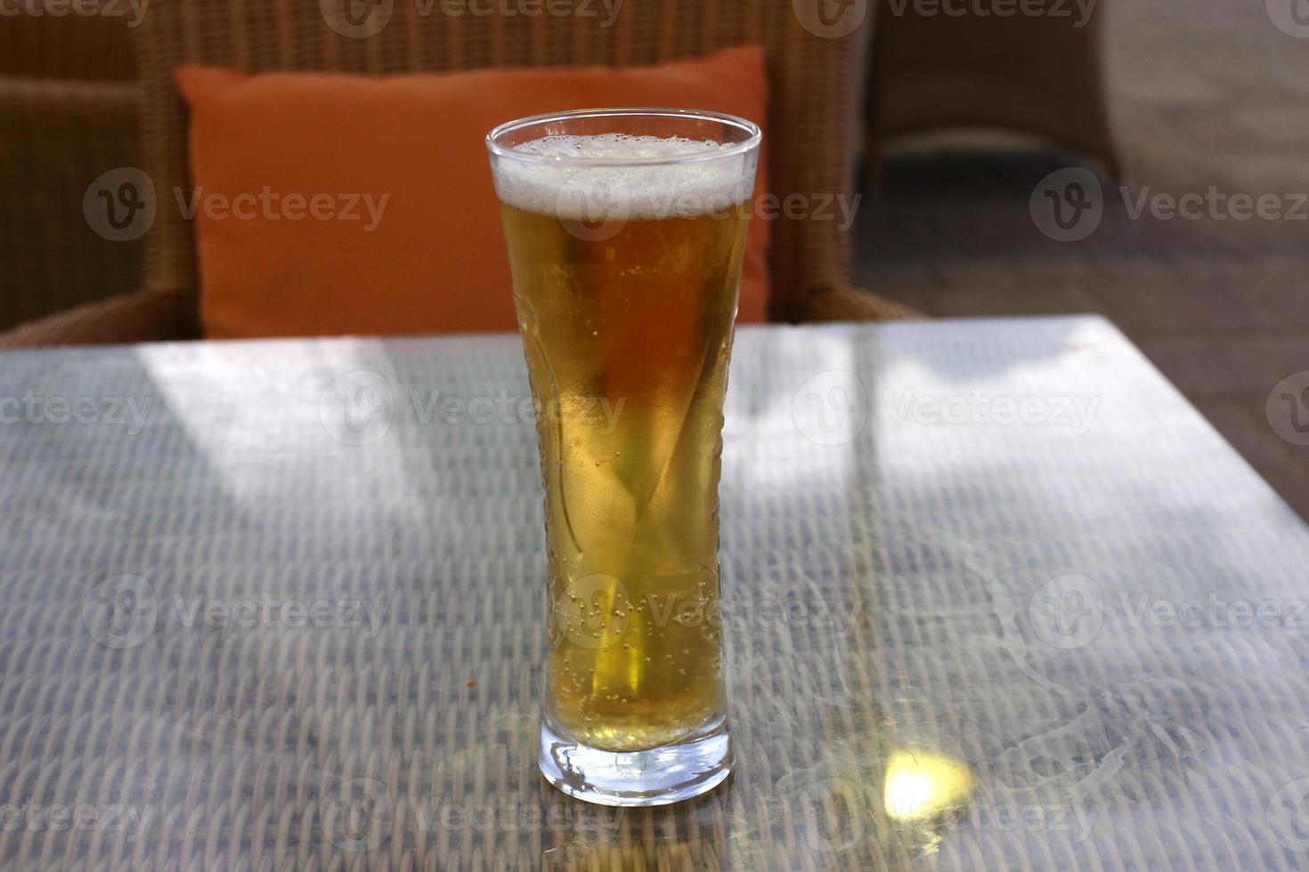 On the table in the restaurant a glass of fresh and cold beer. photo