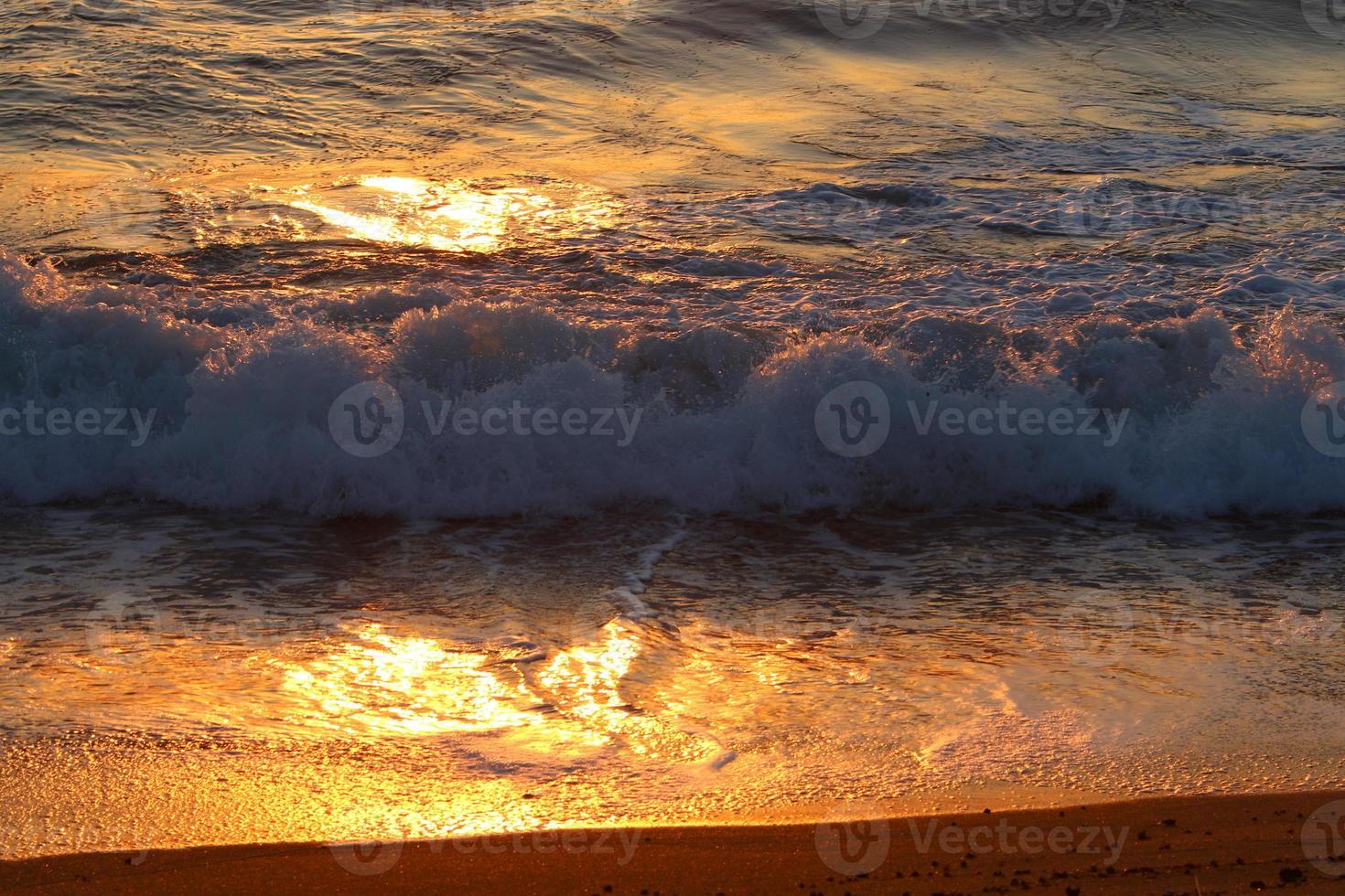 The sun sets below the horizon on the Mediterranean Sea in northern Israel. photo