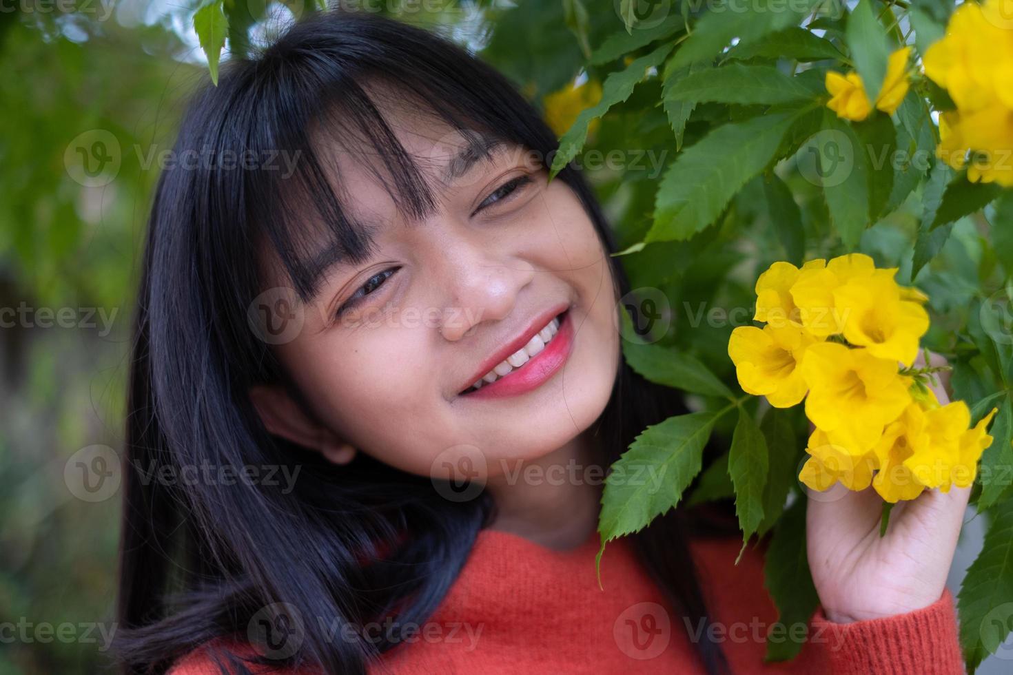 retrato joven con flores amarillas, chica asiática. foto