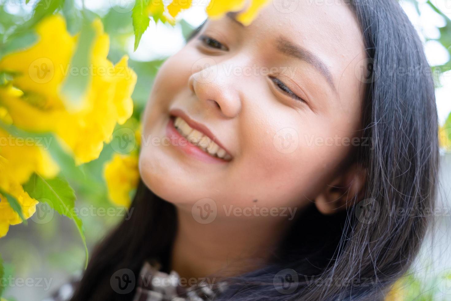 retrato joven con flores amarillas, chica asiática. foto