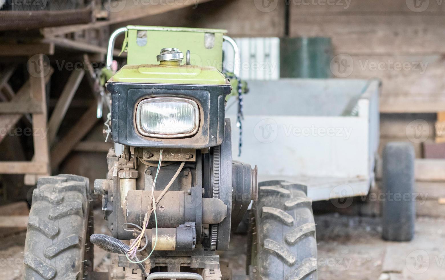 motocultor diésel pesado típico con remolque. equipos de transporte agrícola del campo. equipo agrícola portátil, minitractor ambulante. el sistema de arranque es mecanico y manual. foto