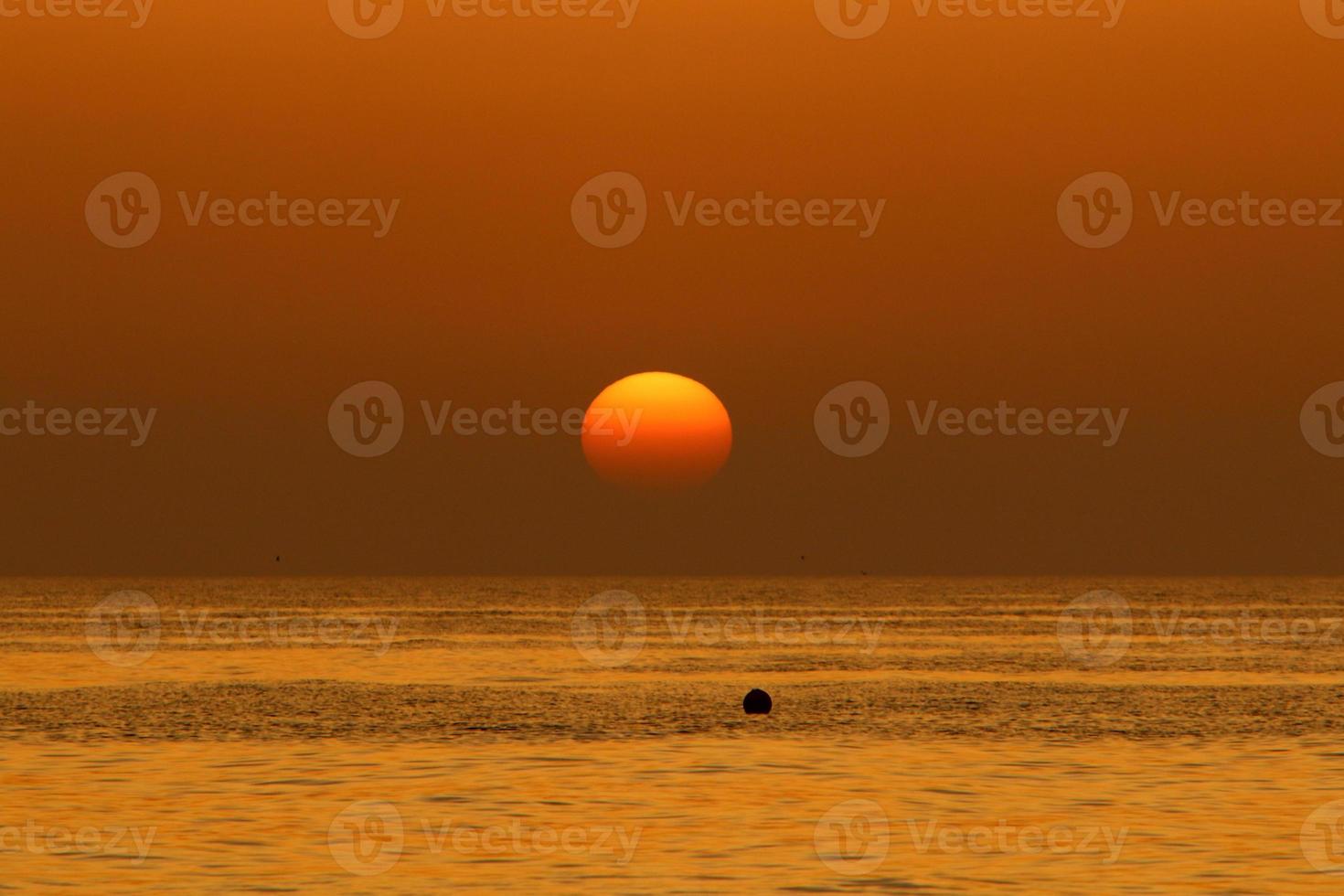 el sol se pone por debajo del horizonte en el mar mediterráneo en el norte de israel. foto