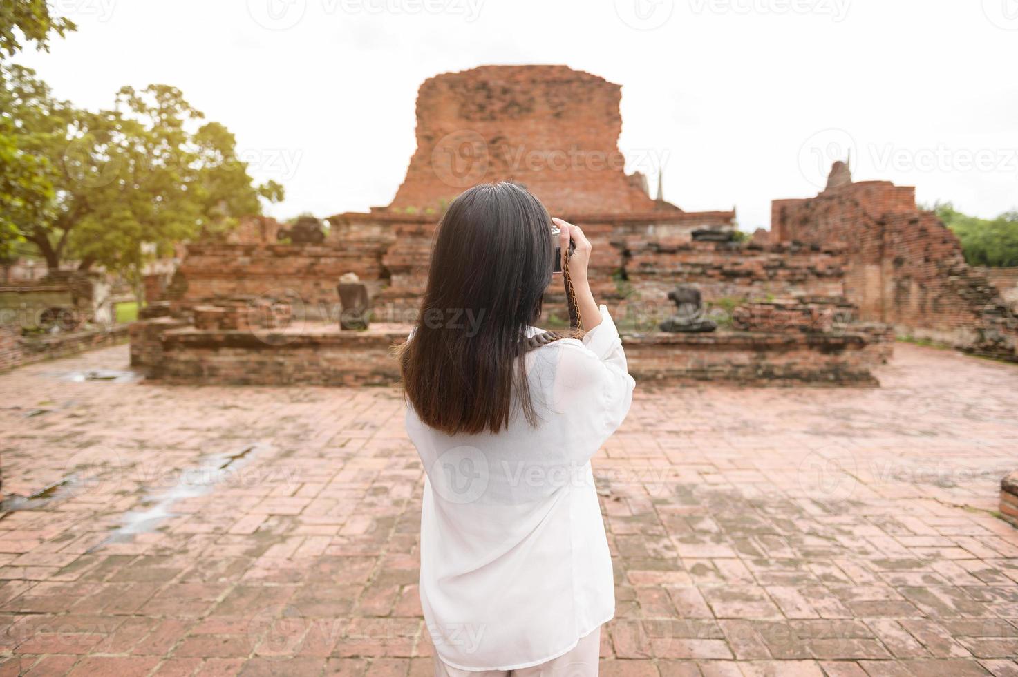 joven hermosa mujer viajando y tomando fotos en el parque histórico tailandés, vacaciones y concepto de turismo cultural.