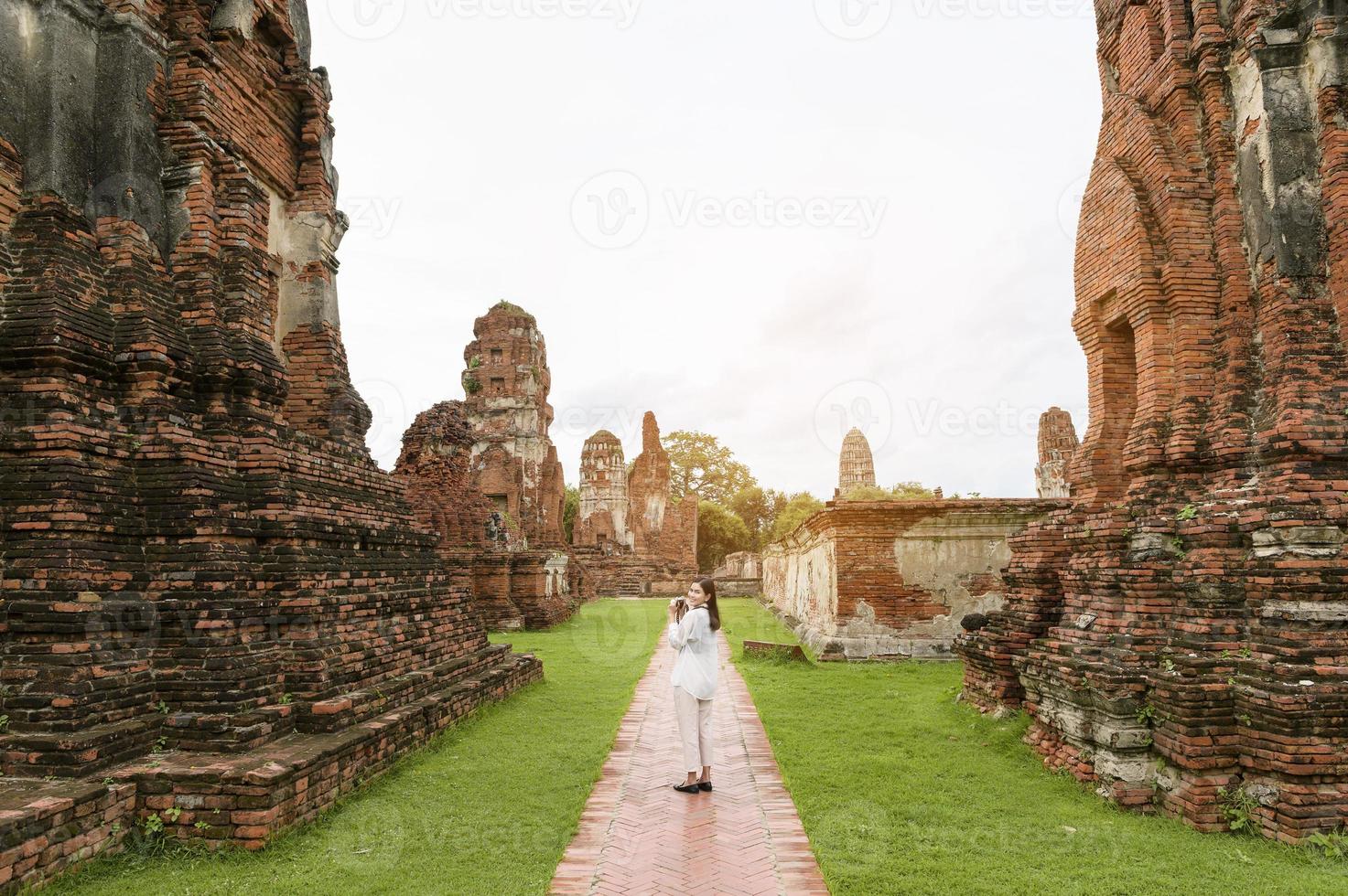 young beautiful woman traveling and taking photo at thai historical Park, Holidays and cultural tourism concept.