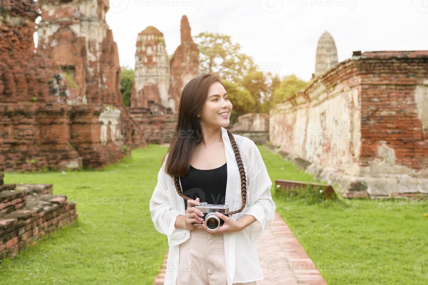 young beautiful woman traveling and taking photo at thai historical Park, Holidays and cultural tourism concept.