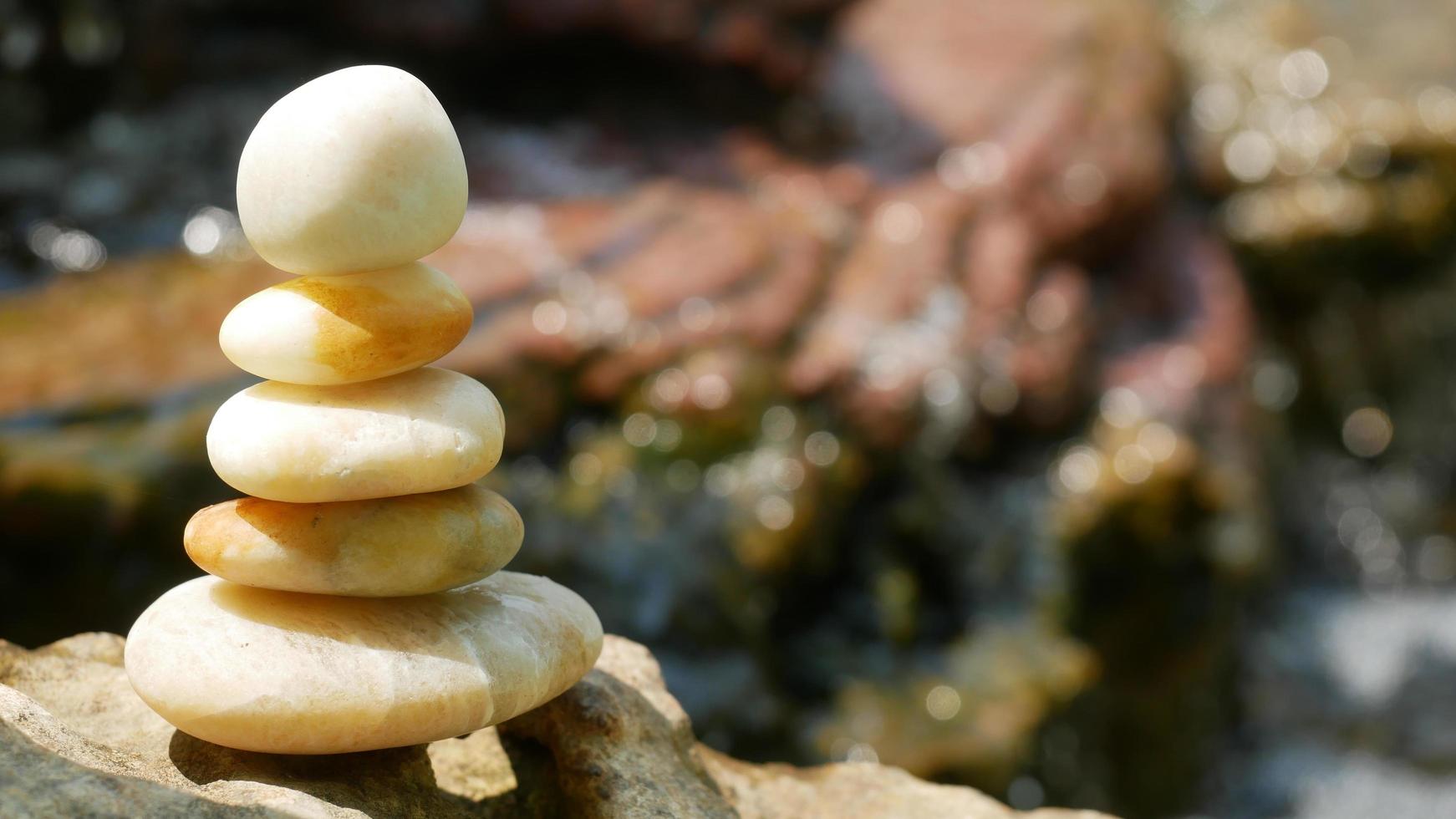 The Balance Stones are stacked as pyramids in a soft natural bokeh background, representing the calm philosophical concept of Jainism's wellness. photo