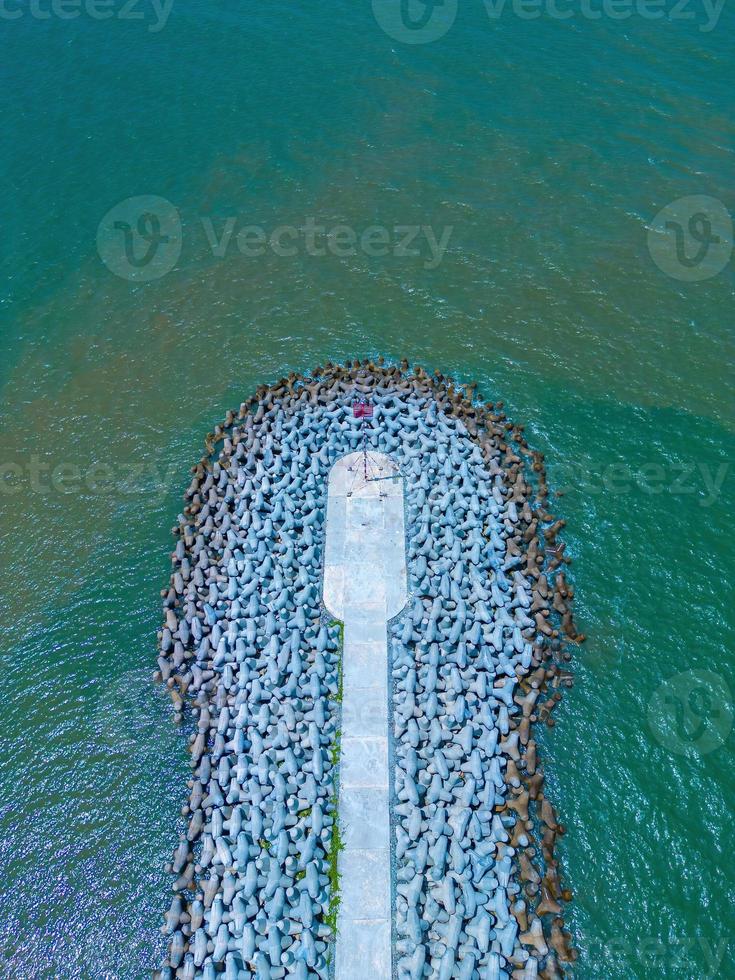 Beautiful blue skyline panoramic in Loc An Canal. Scenery landscape of fishing port with tsunami protection concrete blocks. Cityscape and boats in the sea. Loc An village near Vung Tau City. photo