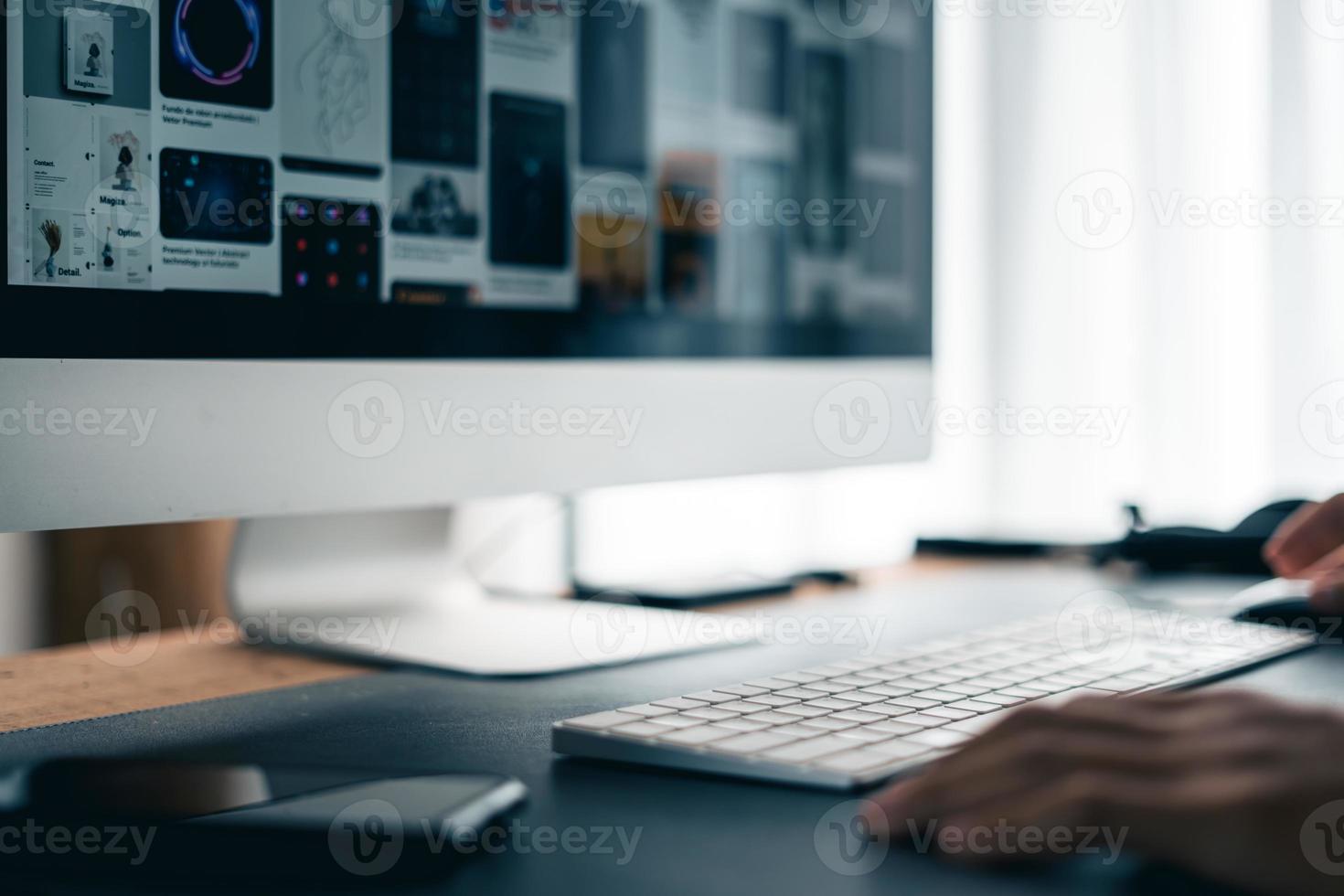 Man working on computer desk at home office photo
