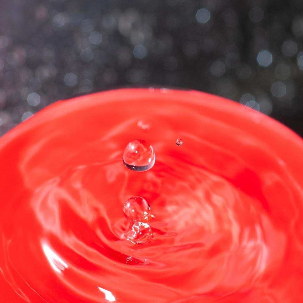 Water Drop On Red Background Close Up photo