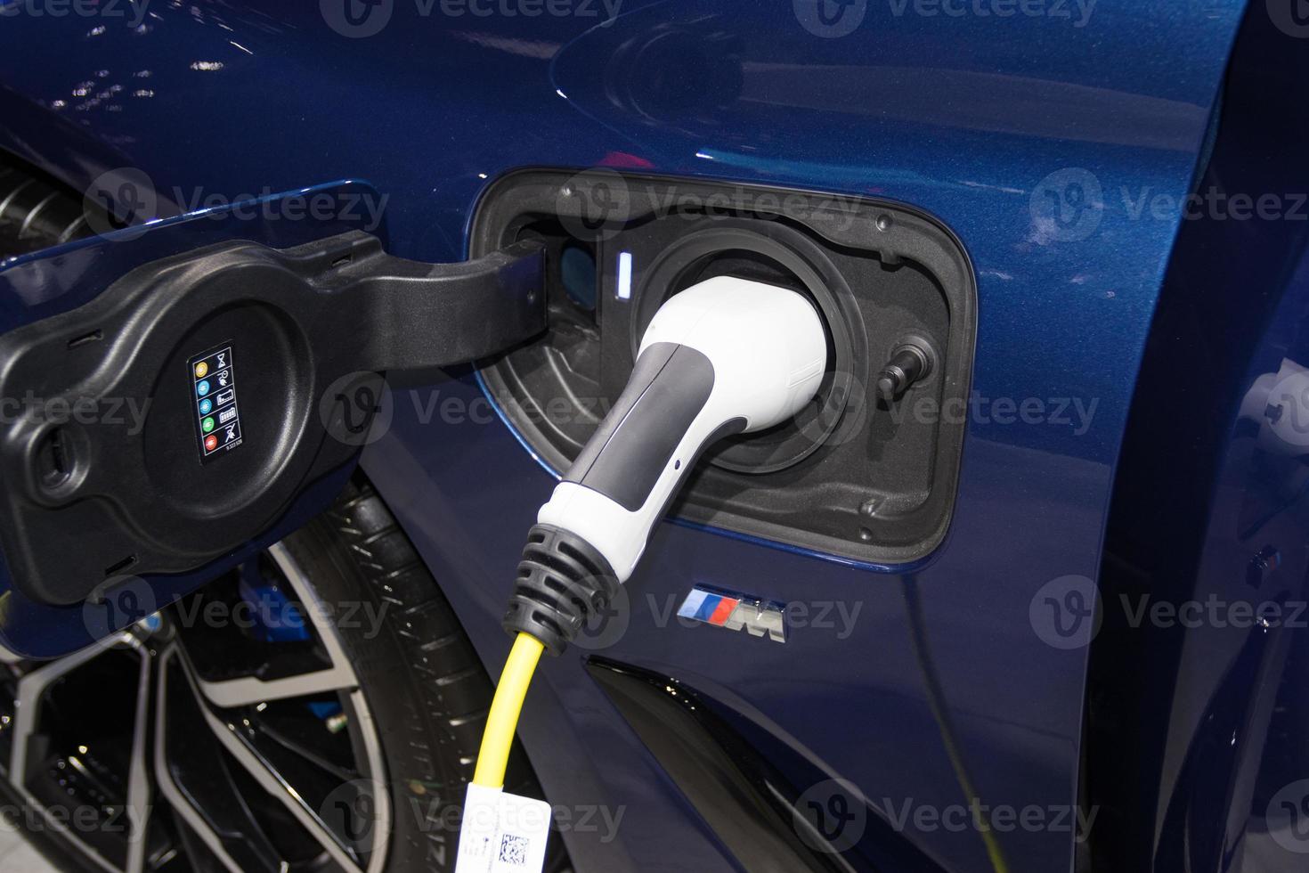 the charging the battery for the car new Automotive Innovations the power supply plugged into an electric car being charged, concept of energy innovation. photo