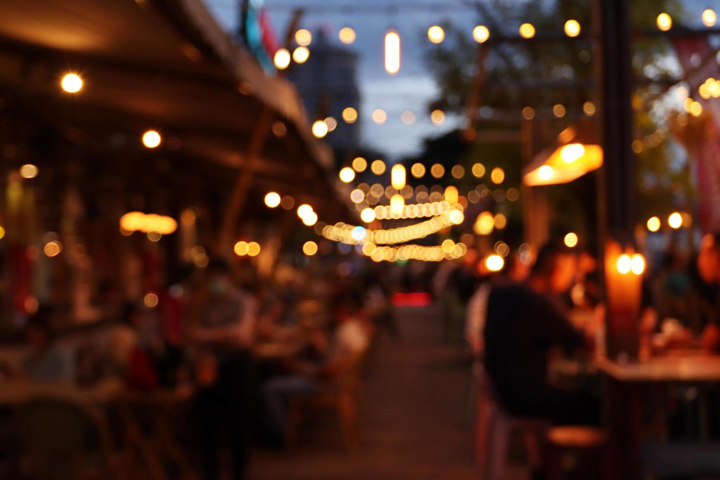 imagen borrosa en la noche del restaurante, muchas personas en el restaurante comen y se divierten felices relajándose foto