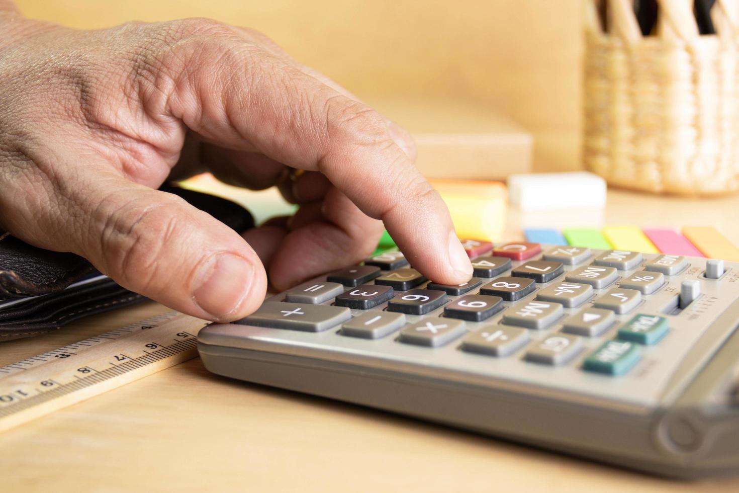 close up human finger push number button of calculator concept Calculation of income, expenditure, calculation photo