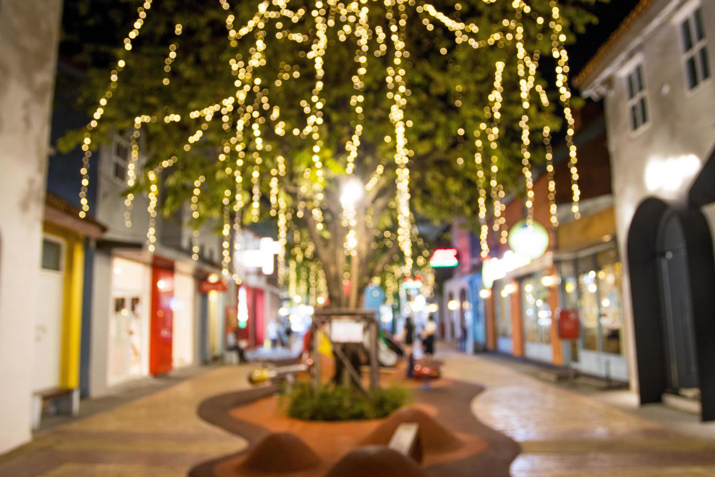 abstract blur image of night festival with a street walk and led light on tree bokeh for background photo