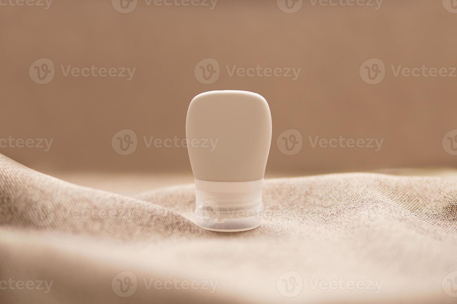 lotion tube mockup isolated on brown fabric background. photo