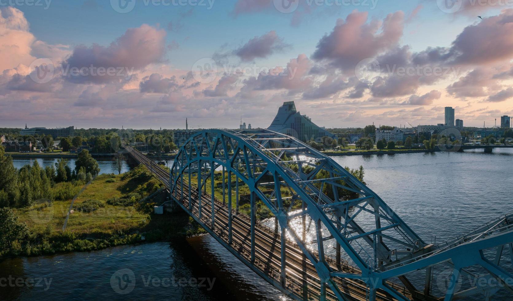 A bridge over river Daugava in Riga with a train passing by. photo