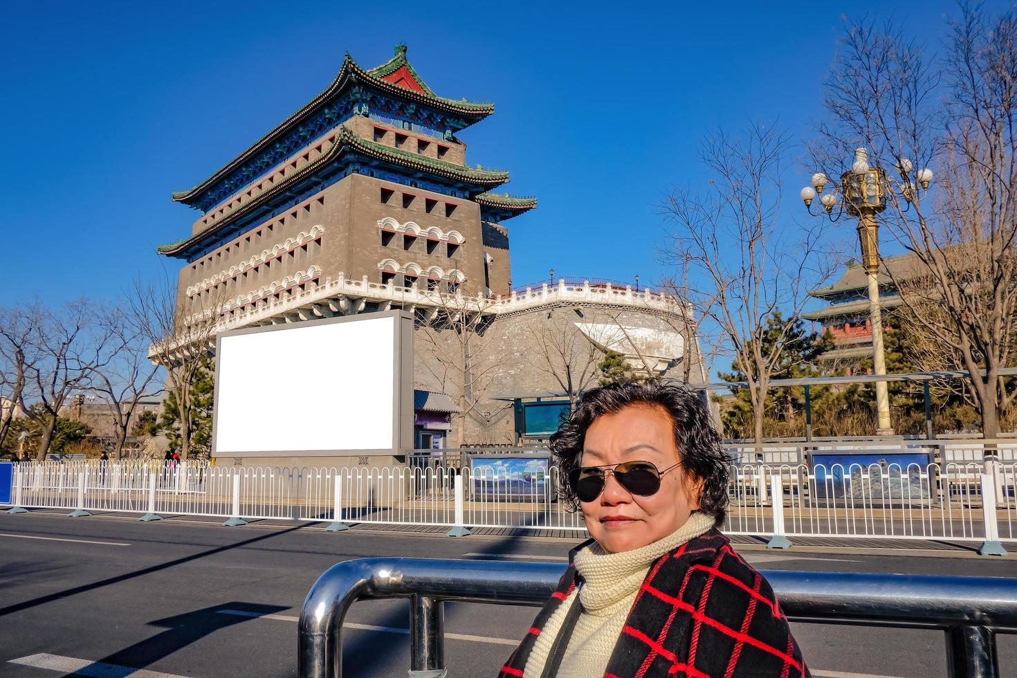 Senior asian women at Zhengyang Gate Jianlou at Qianmen Street and white mock up bill borad.Qianmen street The famous street in beijing Capital City of china photo