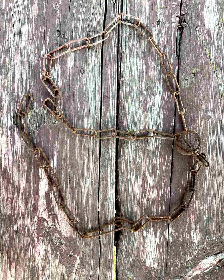 Rusty chain. Rusty chain links on a background of old wood. photo