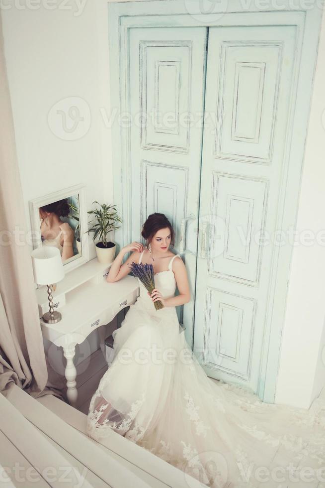 Beautiful young bride in white wedding dress photo