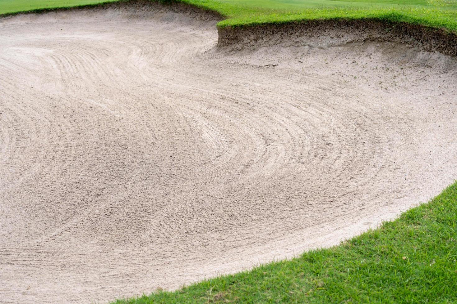 El fondo de la belleza del búnker del arenero se usa como un obstáculo para los torneos de golf por dificultad. y decora el campo para la belleza. hierba verde con textura de arena. foto