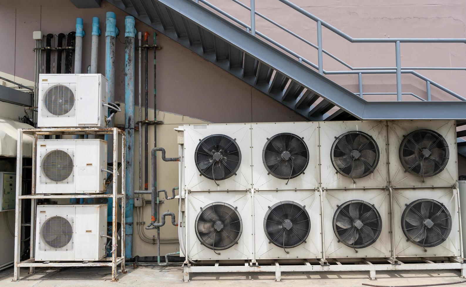 Varios grandes ventiladores de aire acondicionado para hacer circular el aire exterior para enfriar el interior están instalados fuera de los grandes centros comerciales. foto