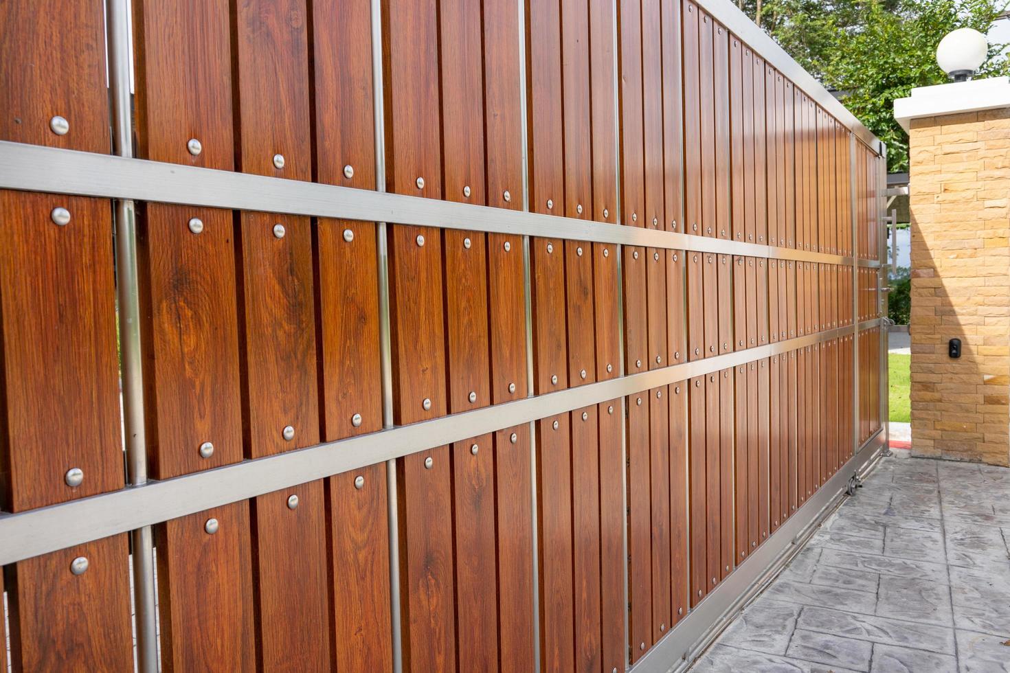 Wooden door in front of house, automatic system can be moved with wheels on side, remote control, the door is made of wood mixed with stainless steel,Security and home decoration for beauty photo