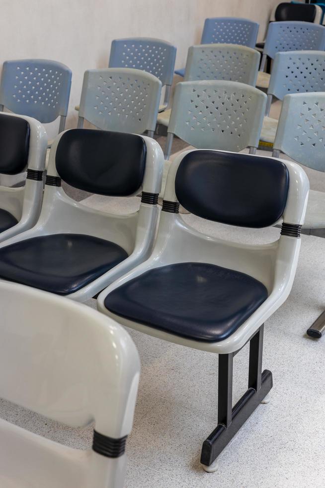 A close-up view of the front of empty black and other chairs. photo