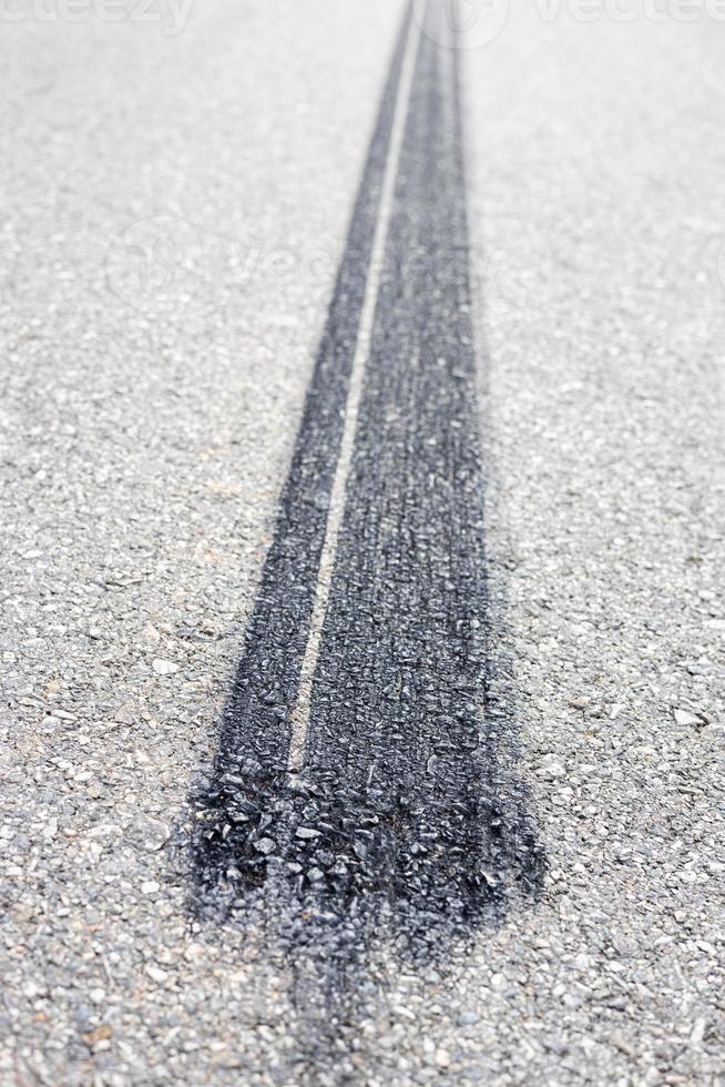 Close-up low view background, black tire traces of automobile wheels which stop braking severely stuck. photo