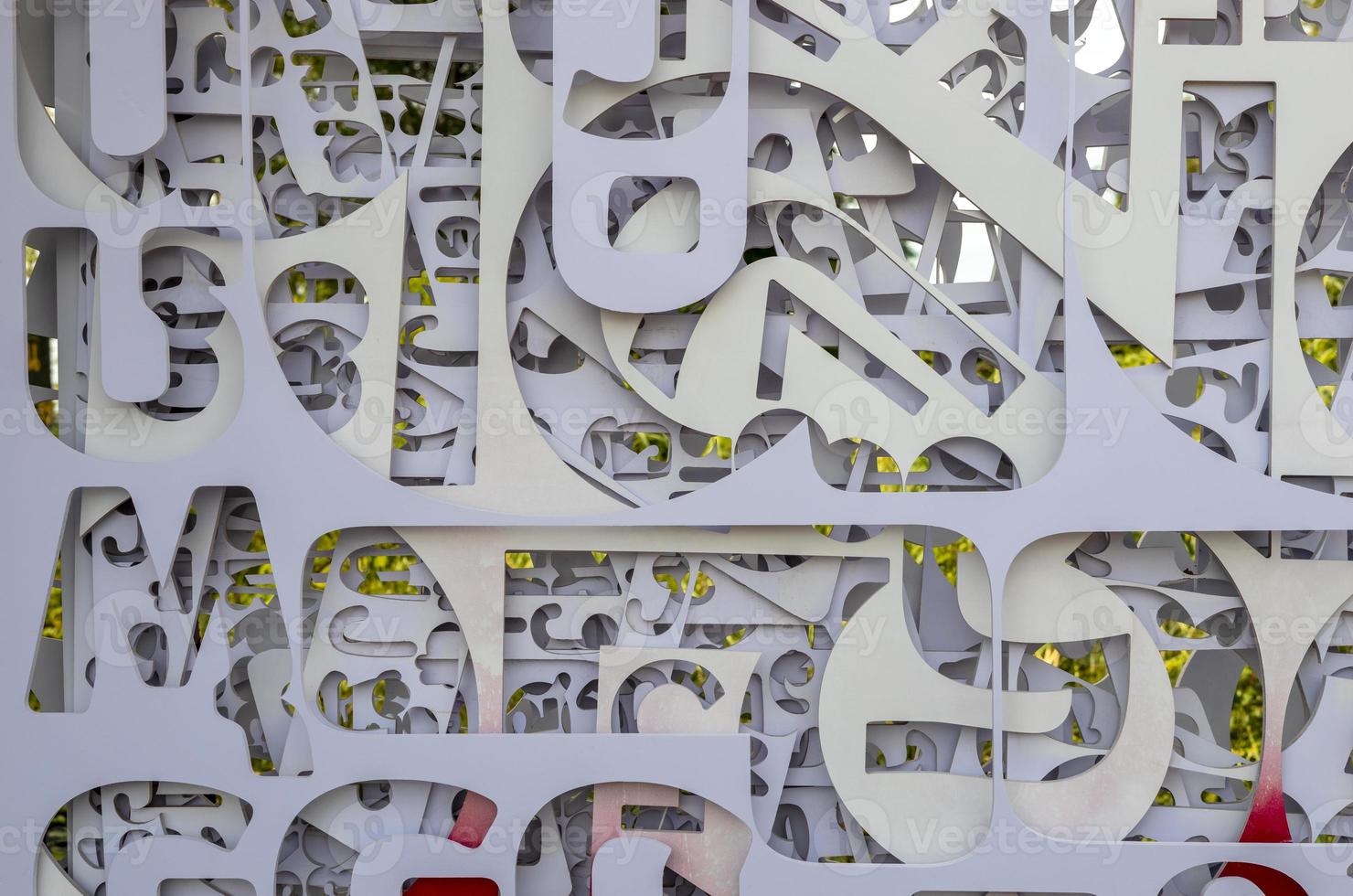 Fragmented backgrounds of white plates, which have been stenciled in letters of various sizes. photo