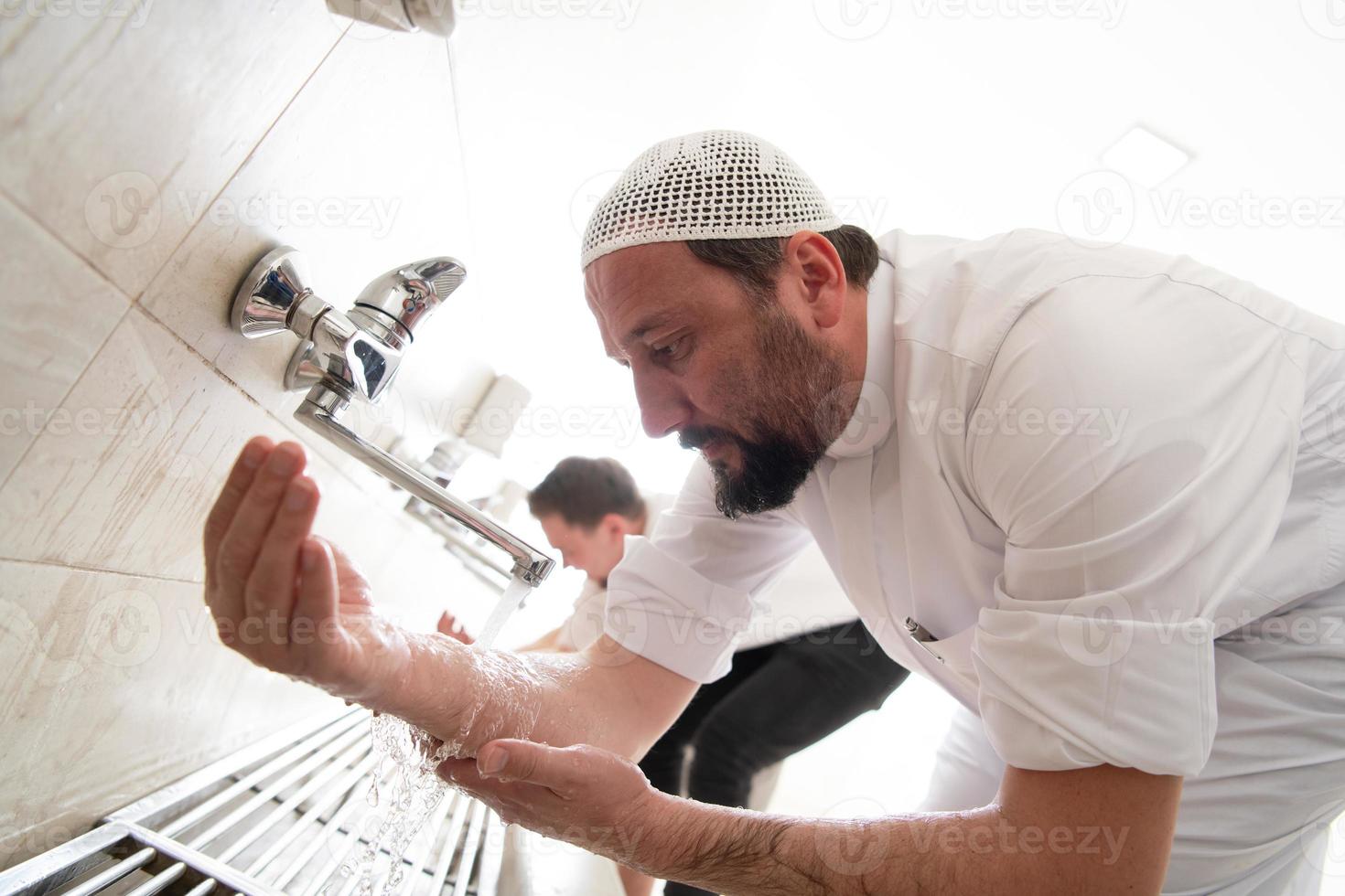 a group of Muslims take ablution for prayer. Islamic religious rite photo