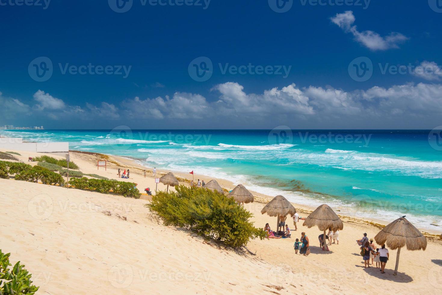 sombrillas en una playa de arena con agua azul en un día soleado cerca de Cancún, México foto