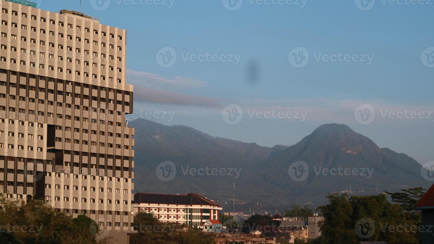 In the morning, you can see apartments next to residents' houses and adjacent to the mountain photo