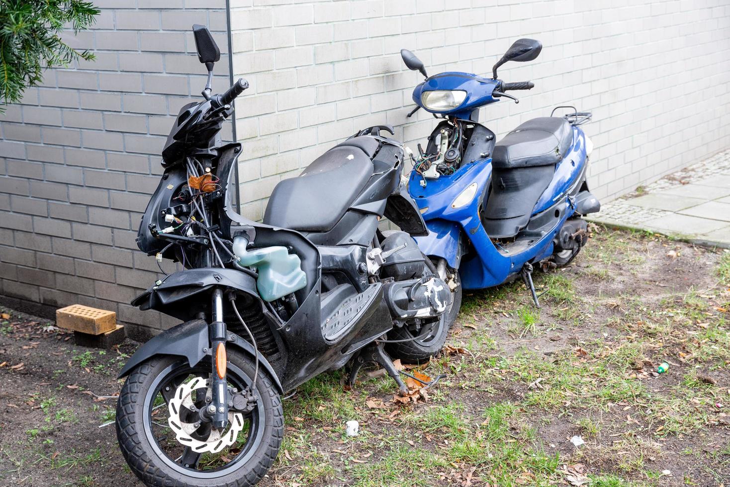 Defective scooters in front of a wall photo