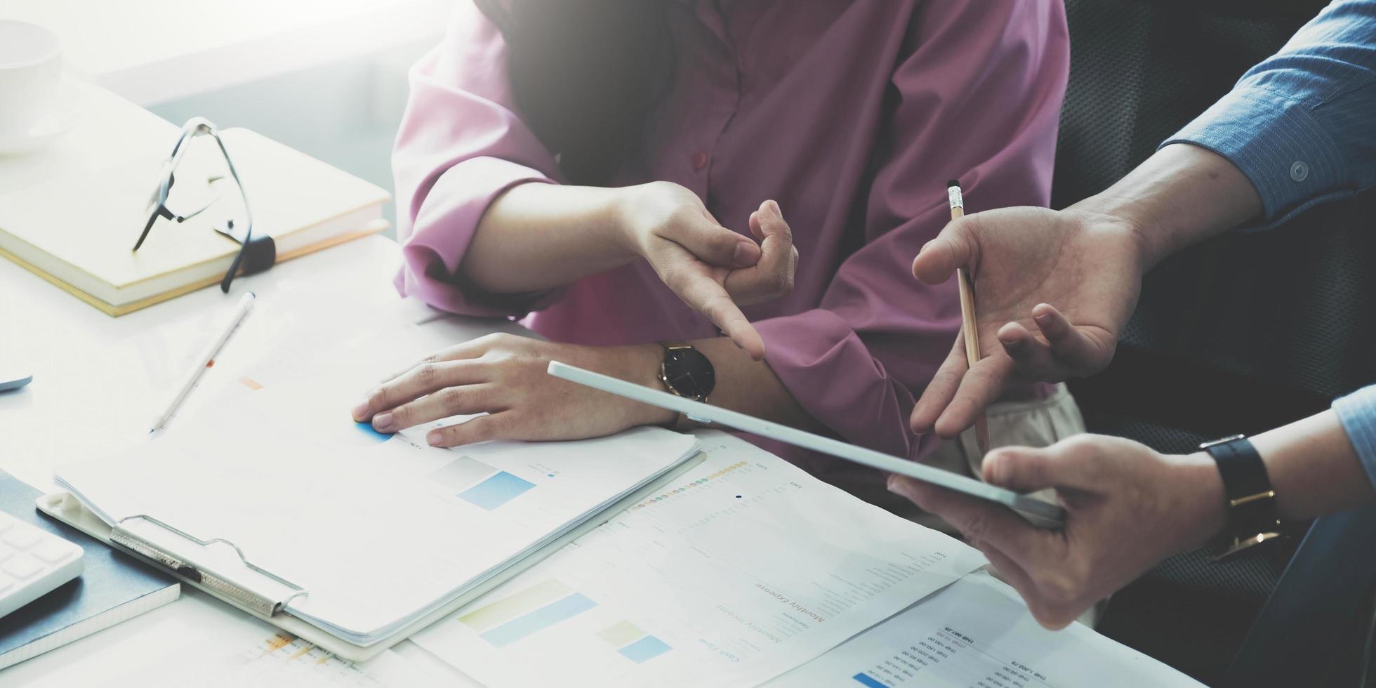 consulta del equipo de gestores de fondos y discute sobre el análisis del mercado de valores de inversión mediante tableta digital. foto