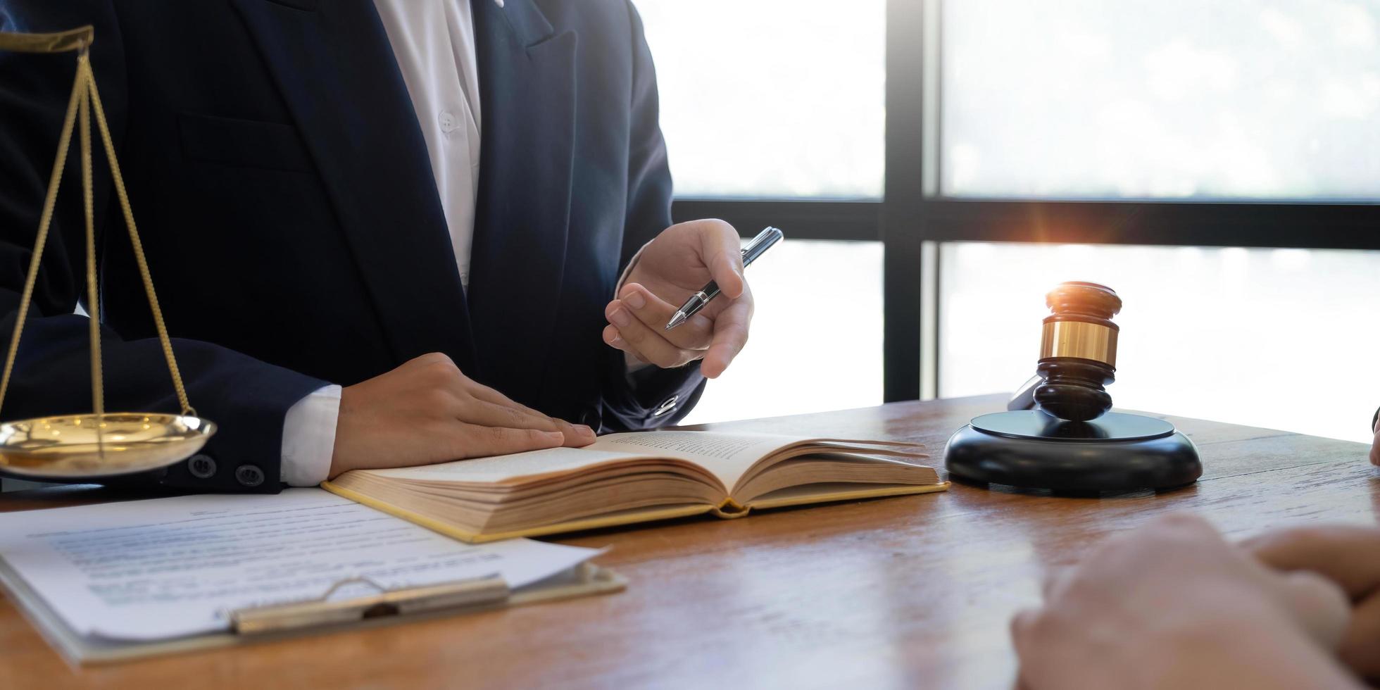 abogado o juez reunido con el cliente consultando ayuda para discutir el acuerdo de papel del contrato foto