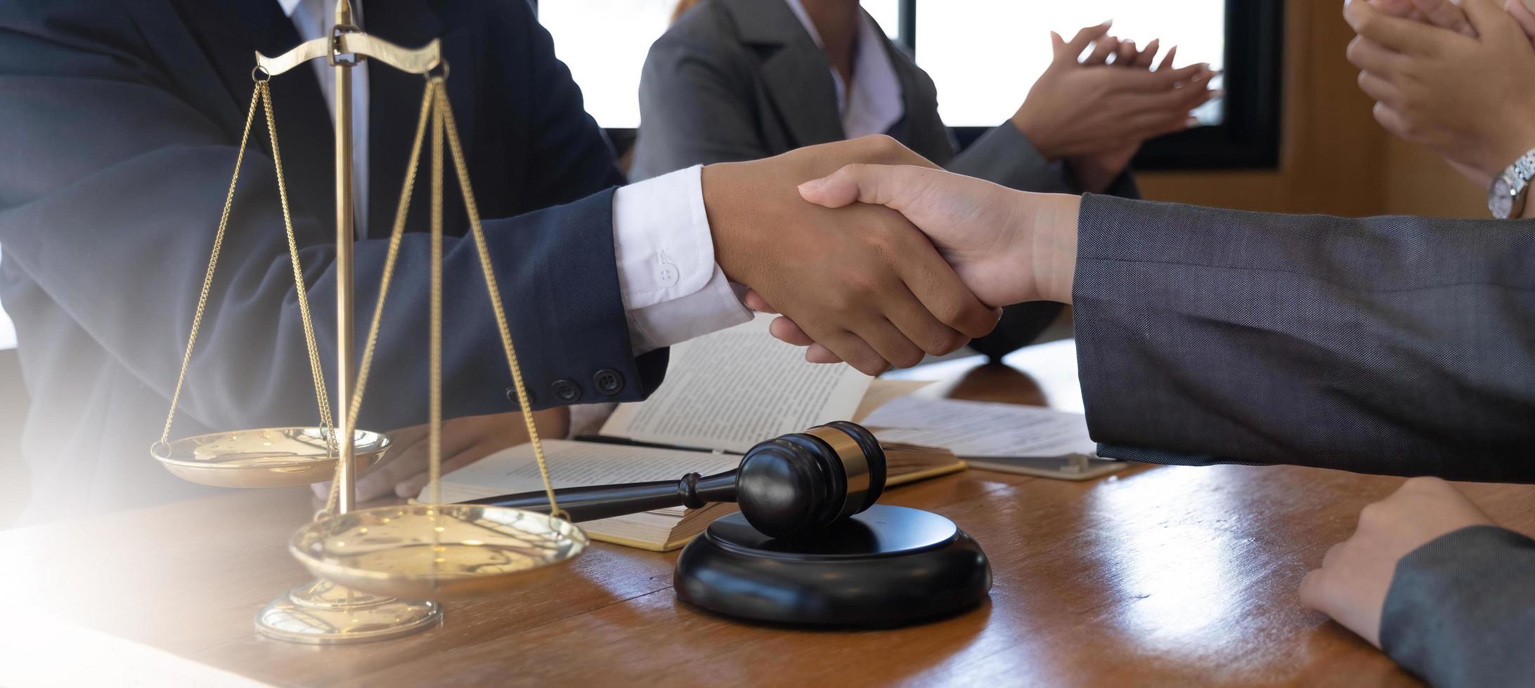 hombre de negocios dándose la mano para sellar un trato con sus socios abogados o abogados discutiendo un acuerdo de contrato. foto