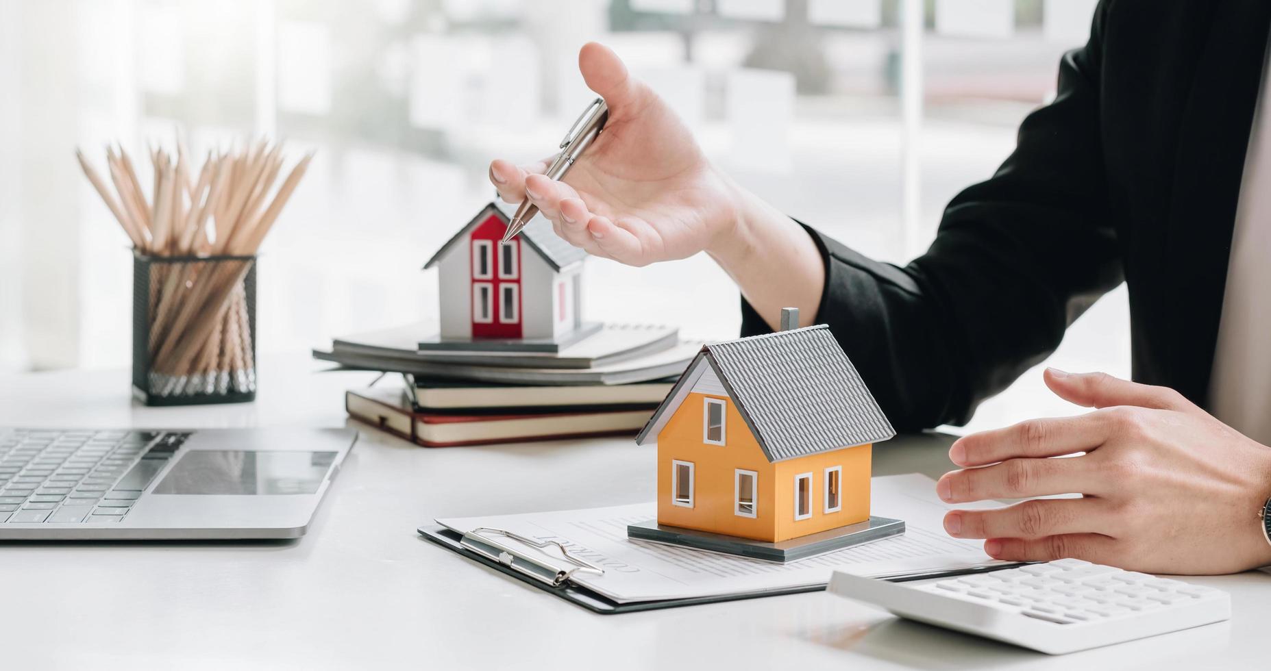 Real estate broker agent presenting and consult to customer to decision making sign insurance form agreement, buy and sell home model, concerning mortgage loan offer for and house insurance photo