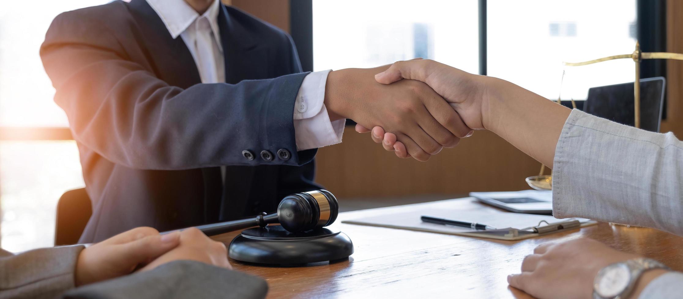 hombre de negocios dándose la mano para sellar un trato con sus socios abogados o abogados discutiendo un acuerdo de contrato. foto