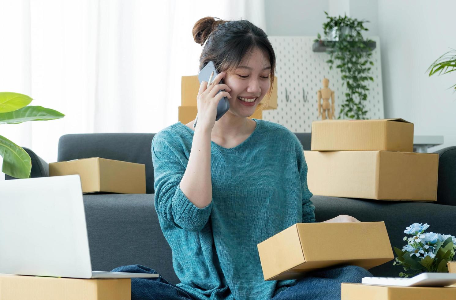 Startup small business entrepreneur SME, asian woman receive order on phone. Portrait young Asian small business owner home office, online sell marketing delivery, SME e-commerce telemarketing concept photo