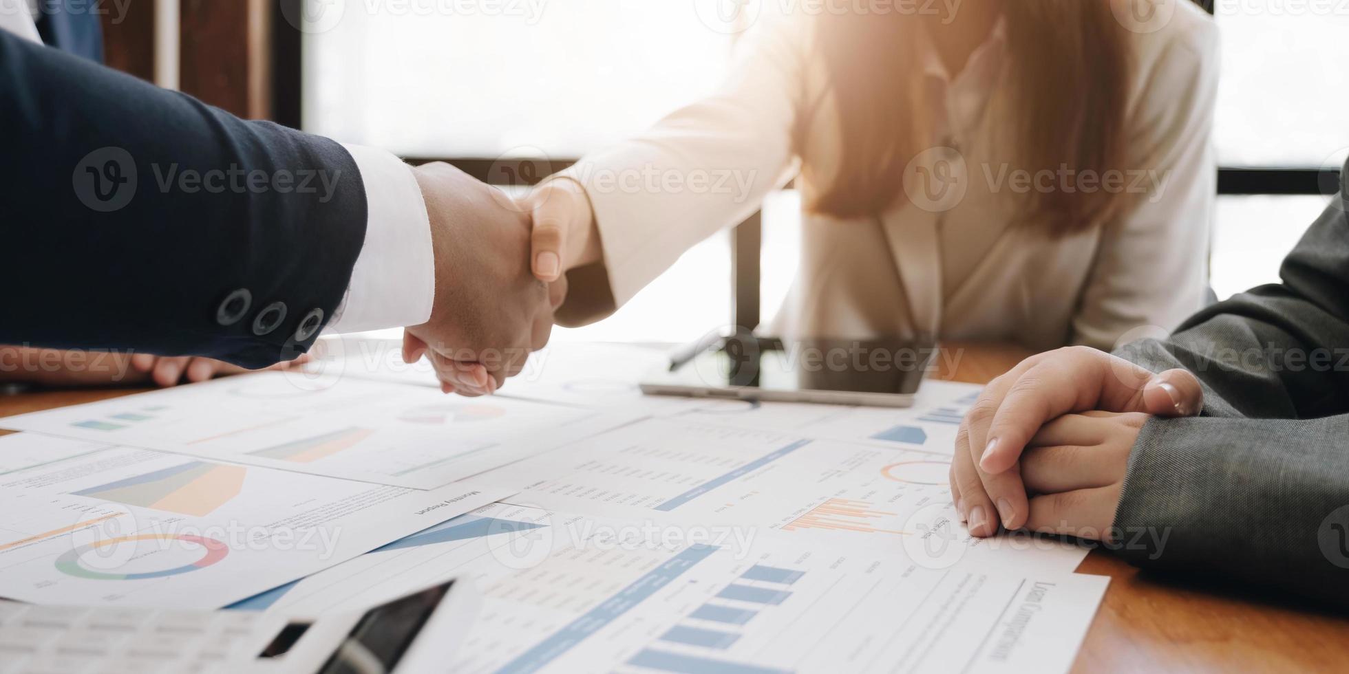 Two confident business man shaking hands during a meeting in the office, success, dealing, greeting and partner concept. photo