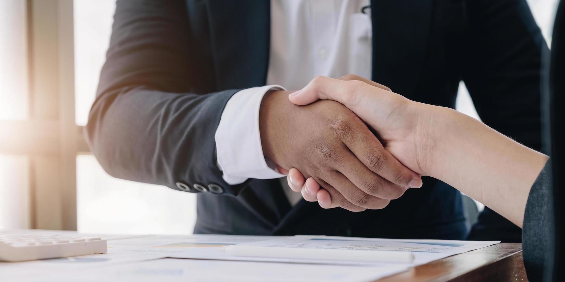 Two confident business man shaking hands during a meeting in the office, success, dealing, greeting and partner concept. photo