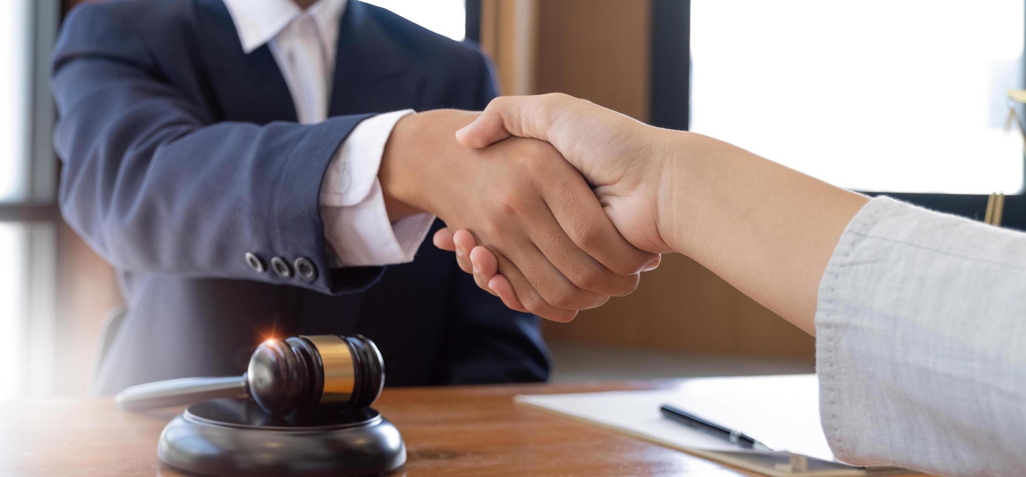 hombre de negocios dándose la mano para sellar un trato con sus socios abogados o abogados discutiendo un acuerdo de contrato foto